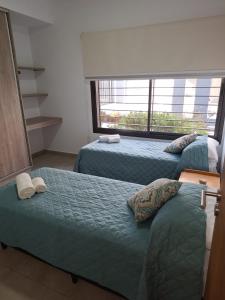 1 dormitorio con 2 camas y ventana grande en Moreno Park Complejo Residencial Bloque 5 Dep 1, Lujan de Cuyo en Luján de Cuyo