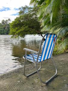 a blue and white chair sitting next to the water at Recanto 3 irmãs in Barreirinhas