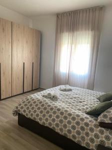 een slaapkamer met een groot bed en een raam bij Lucia's home in Occhiobello