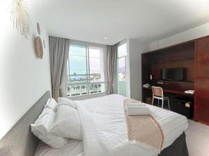 um quarto com uma grande cama branca e uma janela em Chalong inn Phuket em Chalong