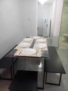 uma mesa longa com pratos e copos de vinho em Casa d'lamour em Aracati