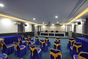 a room with blue and yellow chairs and a stage at Hotel Bhakti in Padang