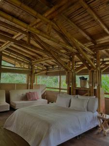 a bedroom with a large bed and a couch at Oasis Santuario de Naturaleza in Ibagué