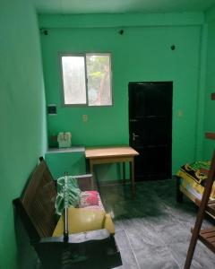 a room with a desk and a green wall at Pedir WhatsApp al instagram iguazucataratashoy - por WhatsApp o mensaje para oficializar la reserva in Puerto Iguazú