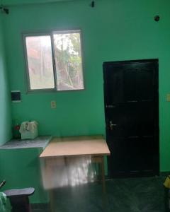 a green room with a bench and a black door at Pedir WhatsApp al instagram iguazucataratashoy - por WhatsApp o mensaje para oficializar la reserva in Puerto Iguazú
