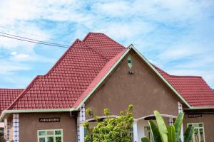 uma casa com um telhado vermelho em AUTOP BG Guest House em Kigali