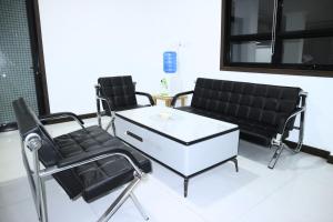 Duas cadeiras e uma mesa de centro num salão em Hotel Bhakti em Padang