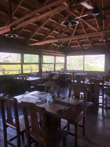 El Nogalito Mina Clavero في Arroyo de Los Patos: غرفة طعام مع طاولات وكراسي ونوافذ