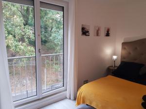 a bedroom with a bed and a large window at Chez Lisa & Olivier in Athis-Mons