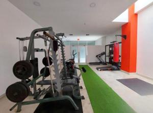 a gym with tread machines and a green carpet at Luxury Suite Wifi & Pool in Guayaquil