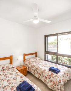 a bedroom with two beds and a window at Villas Las Almenas in Maspalomas +59 photos