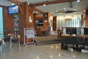 a restaurant with wooden walls and tables and chairs at Anodard Hotel Chiang Mai in Chiang Mai