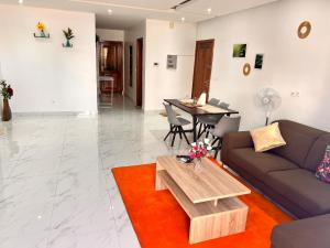 een woonkamer met een bank en een tafel bij LUXE Appartement in Dakar