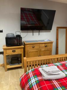 a bedroom with a bed and a tv on the wall at Roblins Nest in Ammanford