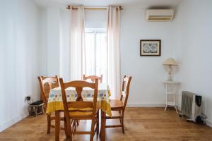 a dining room with a table and chairs and a window at apartamento con parking plaza del museo in Seville