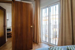 a bedroom with a large glass door to a balcony at apartamento con parking plaza del museo in Seville