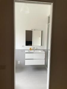 a white bathroom with a sink and a mirror at Lucilio - intero appartamento in Rome