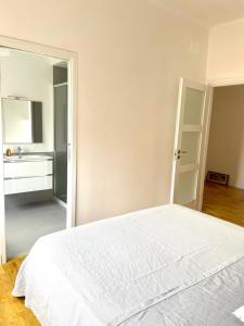 - une chambre avec un lit blanc et un lavabo dans l'établissement Lucilio - intero appartamento, à Rome