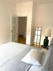 - une chambre avec un grand lit blanc et une lampe dans l'établissement Lucilio - intero appartamento, à Rome