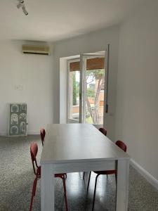 - une table et des chaises blanches dans une chambre avec fenêtre dans l'établissement Lucilio - intero appartamento, à Rome