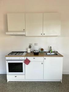 - une cuisine blanche avec cuisinière et évier dans l'établissement Lucilio - intero appartamento, à Rome
