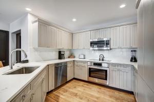 a kitchen with white cabinets and stainless steel appliances at Elkhorn Lodge in Avon