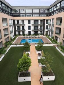 une femme debout devant un grand bâtiment dans l'établissement Just Nice Stays @ The Gardens, à Accra