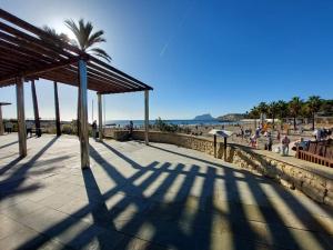 a shadow of a palm tree on a beach at Casita Vida Moraira in Benitachell
