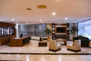 een lobby met een wachtkamer met een bureau en stoelen bij Best Western PLUS Plaza Florida & Tower in Irapuato