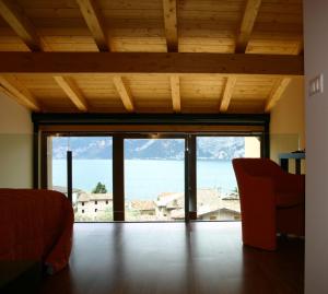 a room with a large window with a view of the ocean at Hotel Garni Selene in Malcesine