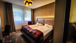 a bedroom with a bed and a large window at Best Western Plus Hotel Willingen in Willingen