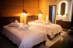 dwa łabędzie na dwóch łóżkach w pokoju hotelowym w obiekcie La Casona w mieście Santa Cruz de la Sierra