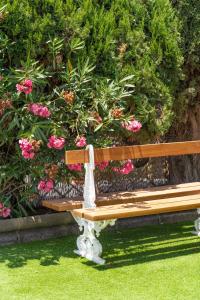 a wooden bench in front of a bush of flowers at Bungalows Las Almenas in Maspalomas