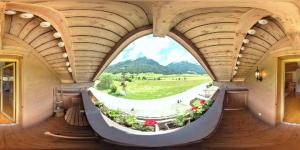 a round window in a building with a view of a garden at Haus Weyerbach Apartments in Bramberg am Wildkogel