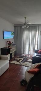 Μια τηλεόραση ή/και κέντρο ψυχαγωγίας στο Apartamento Pitangueiras Centro Guarujá , 150 metros da Praia Vista Mar