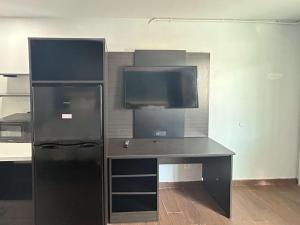 a desk with a black refrigerator in a room at Studio 6 Hemet, CA in Hemet