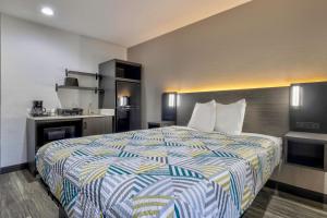 une chambre d'hôtel avec un lit et une cuisine dans l'établissement Studio 6 Little Rock AR South, à Little Rock