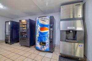 a large refrigerator in a room with a drink machine at Studio 6 Little Rock AR South in Little Rock