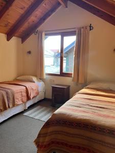 1 dormitorio con 2 camas y ventana en Bandurria en Esquel