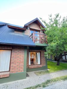 a brick house with a blue roof at Bandurria in Esquel