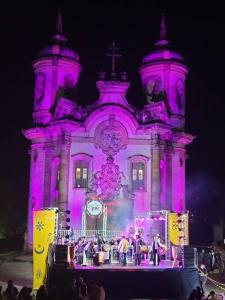 a group of people on a stage in front of a building at Casa completa próxima a Ouro Preto! Amarantina in Ouro Preto