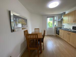 a kitchen with a table and chairs in a room at Lovely one bedroom garden flat in Hendon in The Hyde