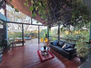 a living room with a black couch and a table at Casa completa próxima a Ouro Preto! Amarantina in Ouro Preto