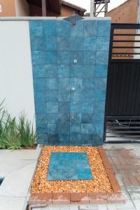 una pared de azulejos azules junto a un edificio en Carolekerry Apartments, en São Sebastião