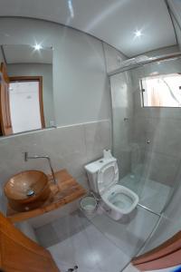 een badkamer met een toilet en een glazen douche bij Carolekerry Apartments in São Sebastião
