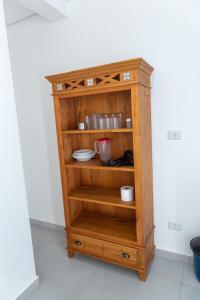 una estantería de madera con platos. en Carolekerry Apartments en São Sebastião