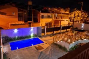 una imagen de una piscina por la noche en Carolekerry Apartments en São Sebastião