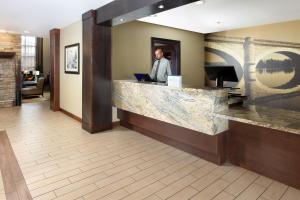 a man standing at a counter in a hotel lobby at Staybridge Suites Sacramento-Folsom, an IHG Hotel in Folsom