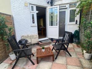 a patio with two chairs and a table and a grill at Lovely one bedroom garden flat in Hendon in The Hyde