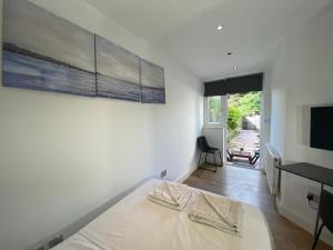 a bedroom with a bed and a desk and a television at Lovely one bedroom garden flat in Hendon in The Hyde